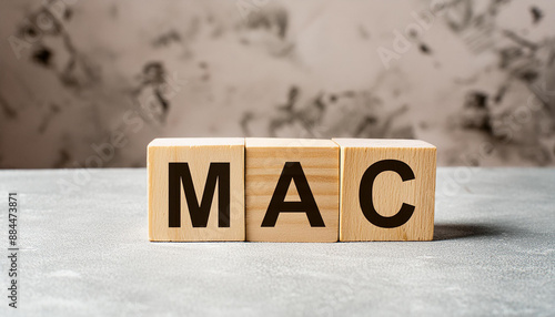 Wooden cubes with abbreviation MAC, cement background. Media Access Control. Online security photo