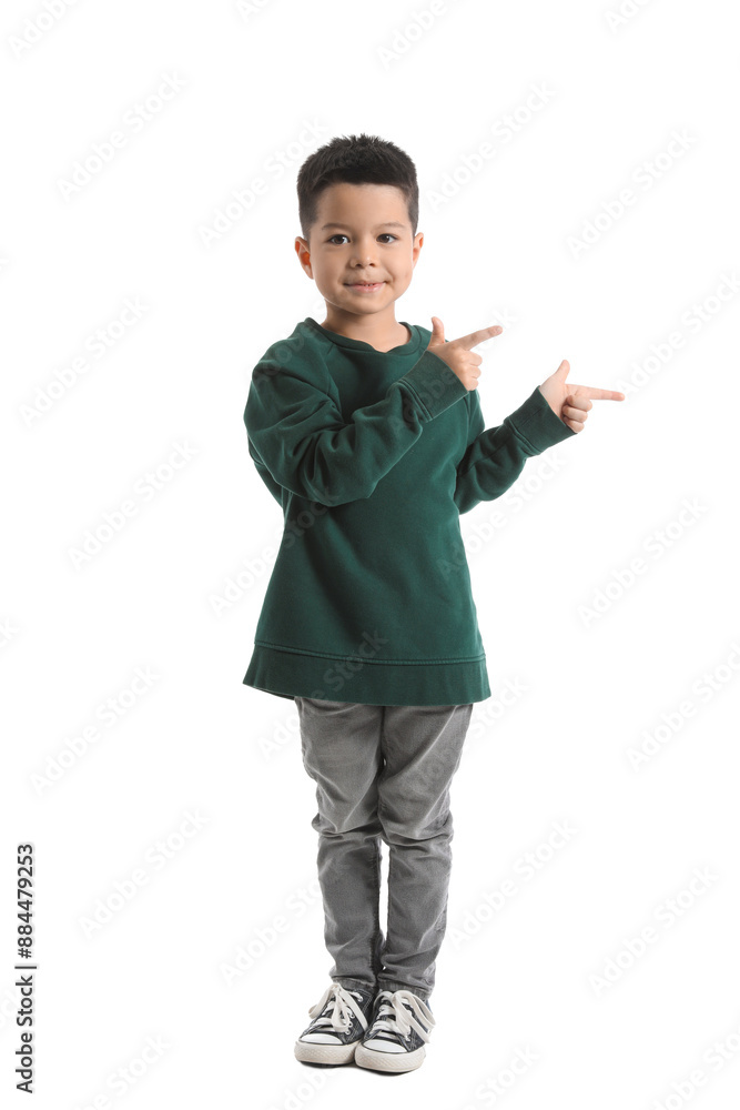 Cute little boy in knitted sweater pointing at something on white background Cute little boy in knitted sweater pointing at something on white background