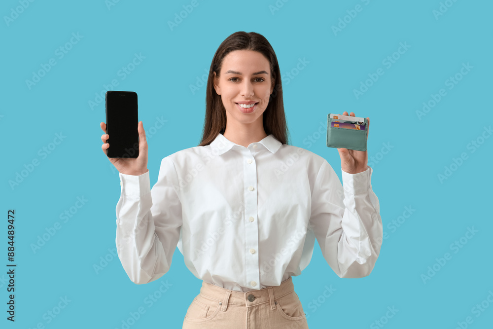 Woman with credit card holder and phone on blue background Woman with credit card holder and phone on blue background