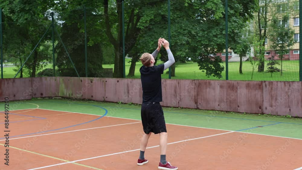 Volleyball player practices volleyball skills with a ball on outdoor court. Passing, hitting, digging. Automation of movement. Special drills Volleyball player practices volleyball skills with a ball on outdoor court. Passing, hitting, digging. Automation of movement. Special drills