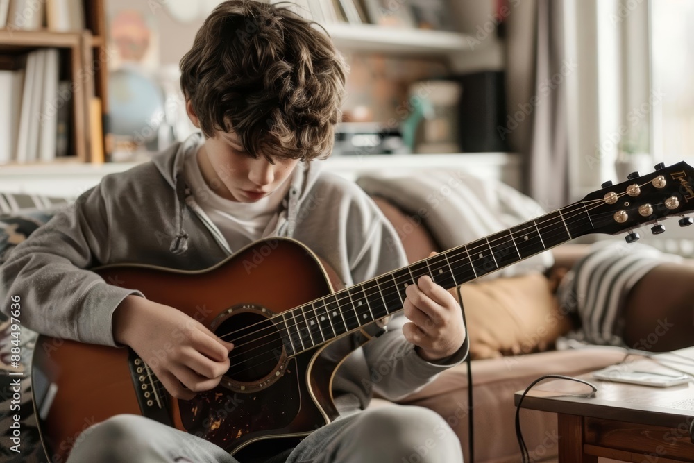 Fototapeta premium Close-up of a boy playing guitar in a living room, focused expression, natural light, photorealistic detail, young musician, cozy home setting, guitar practice, detailed scene