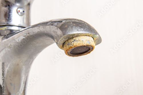Rusty deposits of hard water on aerator. Plaque and rust on the faucet