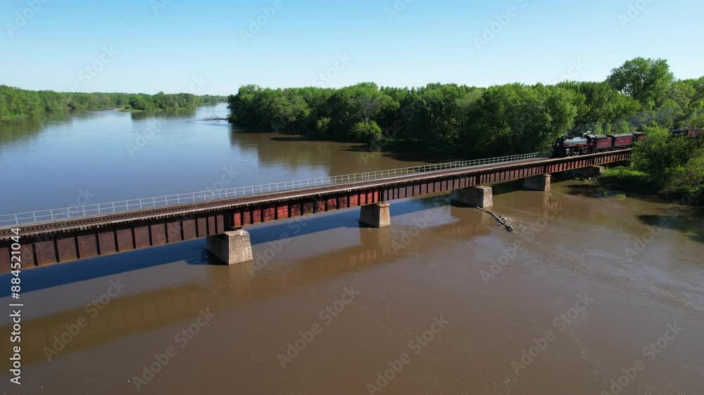 IOWA - 6.24.2024 - Great aerial view pulling back from a Canadian Pacific steam train traveling on a bridge over the Iowa River. IOWA - 6.24.2024 - Great aerial view pulling back from a Canadian Pacific steam train traveling on a bridge over the Iowa River.