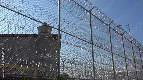 IOWA - 6.28.2024 - Establishing shot of the Iowa State Penitentiary seen through the barbed wire fence.