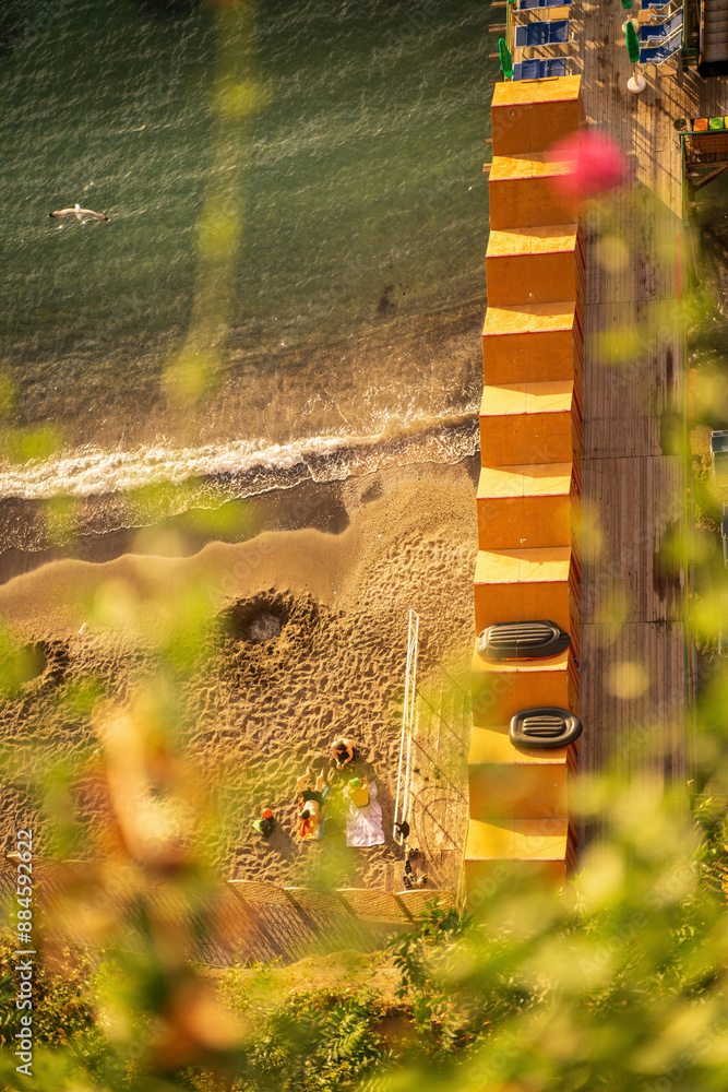 People relaxing on a beach during summer in the beach of sorrento, Italy during golden hour