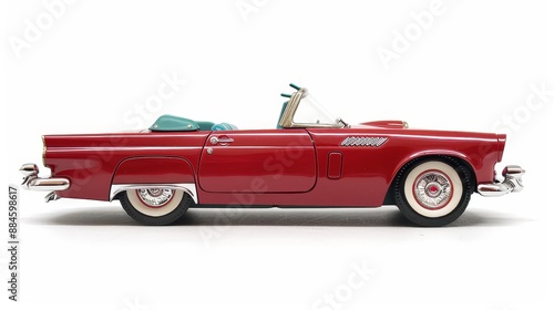 A metalic classic toy car convertible is isolated on a white backdrop.