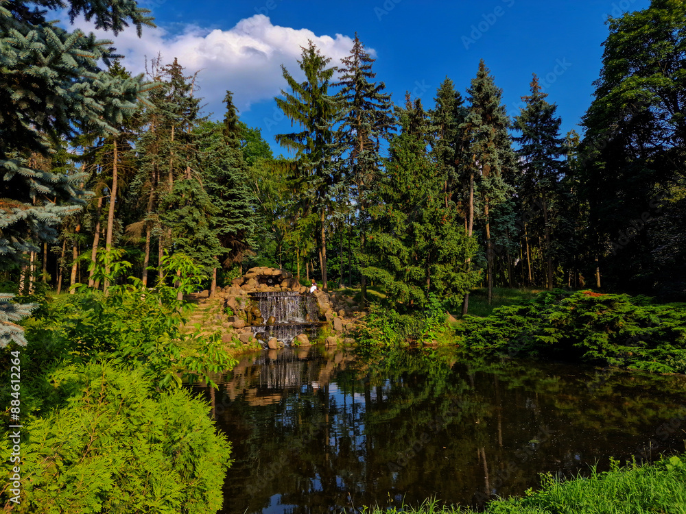 Fototapeta premium Landscape with cascading waterfall in scenic Skaryszewski Park in Warsaw, Poland