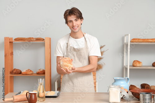 Smiling young male baker ho...