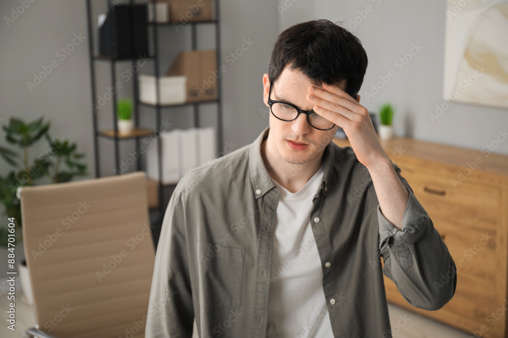 Embarrassed young man in glasses in office Embarrassed young man in glasses in office