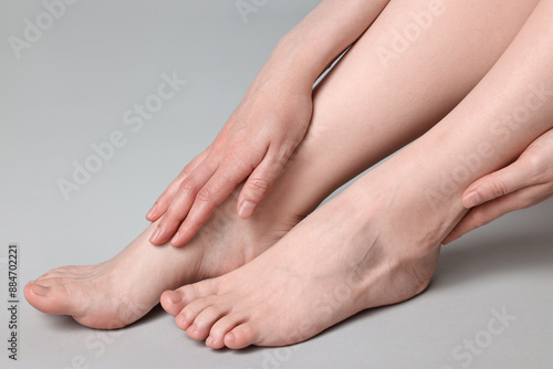 Closeup view of woman`s groomed feet after care procedure on grey background