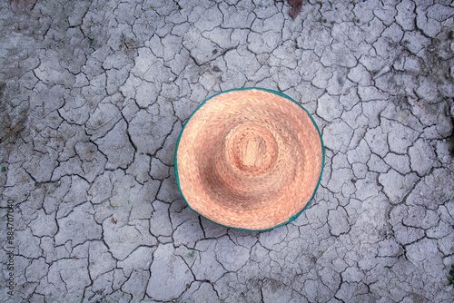 A farmer's hat, a harvest hat, lay on the cracked ground.