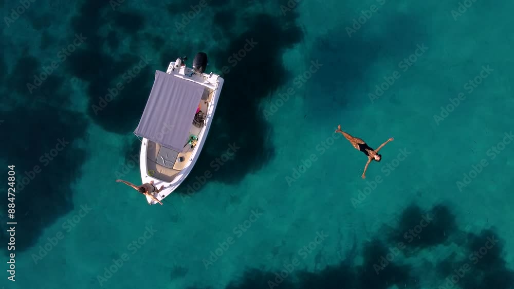 Young Couple Enjoying Turquoise Paradisiacal Sea Waters with a Boat Young Couple Enjoying Turquoise Paradisiacal Sea Waters with a Boat