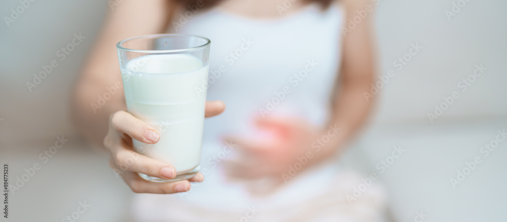 Lactose intolerance and Milk allergy concept. woman hold Milk glass and having abdominal cramps and pain when drink Cow Milk. Symptom stomach ache, Dairy intolerant, Nausea, Bloating, Gas and Diarrhea Lactose intolerance and Milk allergy concept. woman hold Milk glass and having abdominal cramps and pain when drink Cow Milk. Symptom stomach ache, Dairy intolerant, Nausea, Bloating, Gas and Diarrhea