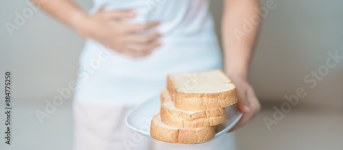 Gluten intolerance, Gluten free and celiac disease or wheat allergy concept. woman hold Bread and having abdominal pain after eat gluten. stomach ache, Nausea, Bloating, Gas, Diarrhea and Skin rash photo