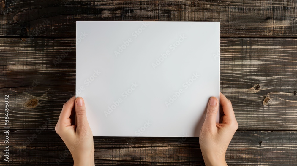 Hands Holding Blank White Paper on Rustic Wooden Table Background Hands Holding Blank White Paper on Rustic Wooden Table Background