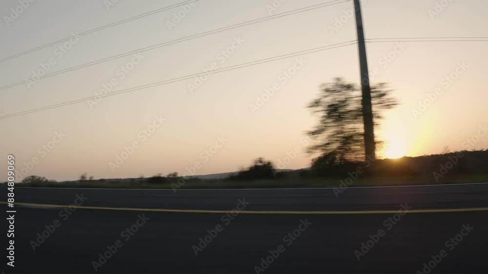 Side angle driving fast on asphalt country road with double yellow line markings at sunset Side angle driving fast on asphalt country road with double yellow line markings at sunset