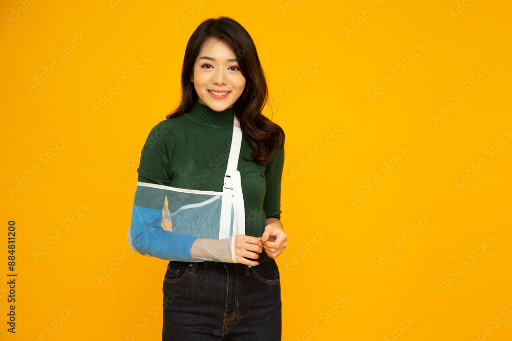 Young Asian woman put on a soft splint due to a broken arm isolated on yellow background, Personal accident concept Young Asian woman put on a soft splint due to a broken arm isolated on yellow background, Personal accident concept
