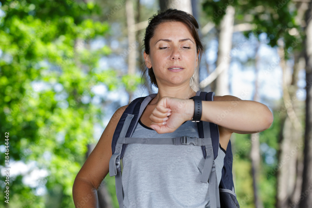 female hiker looking at her wristwatch female hiker looking at her wristwatch