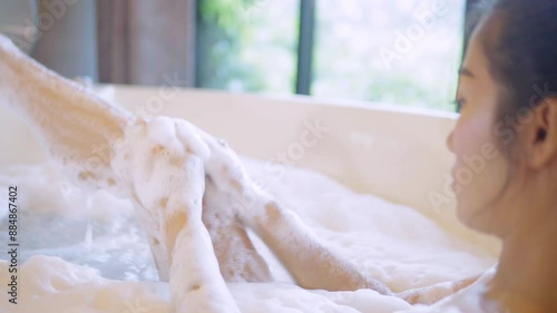 Sexy Asian girl taking a foam bath in the bathtub.