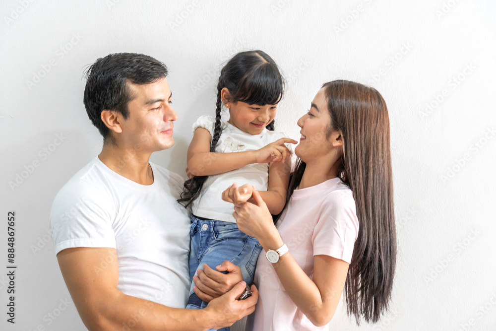 Portrait of enjoy happy love asian family father and mother holding hug cute little asian girl child smiling play and having fun moments good time, care, kid, support, insurance, child, at home Portrait of enjoy happy love asian family father and mother holding hug cute little asian girl child smiling play and having fun moments good time, care, kid, support, insurance, child, at home