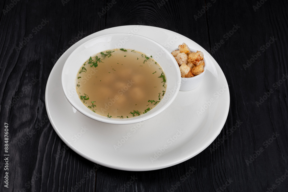 Chicken soup bouillon in a plate with chicken meatballs and croutons Chicken soup bouillon in a plate with chicken meatballs and croutons
