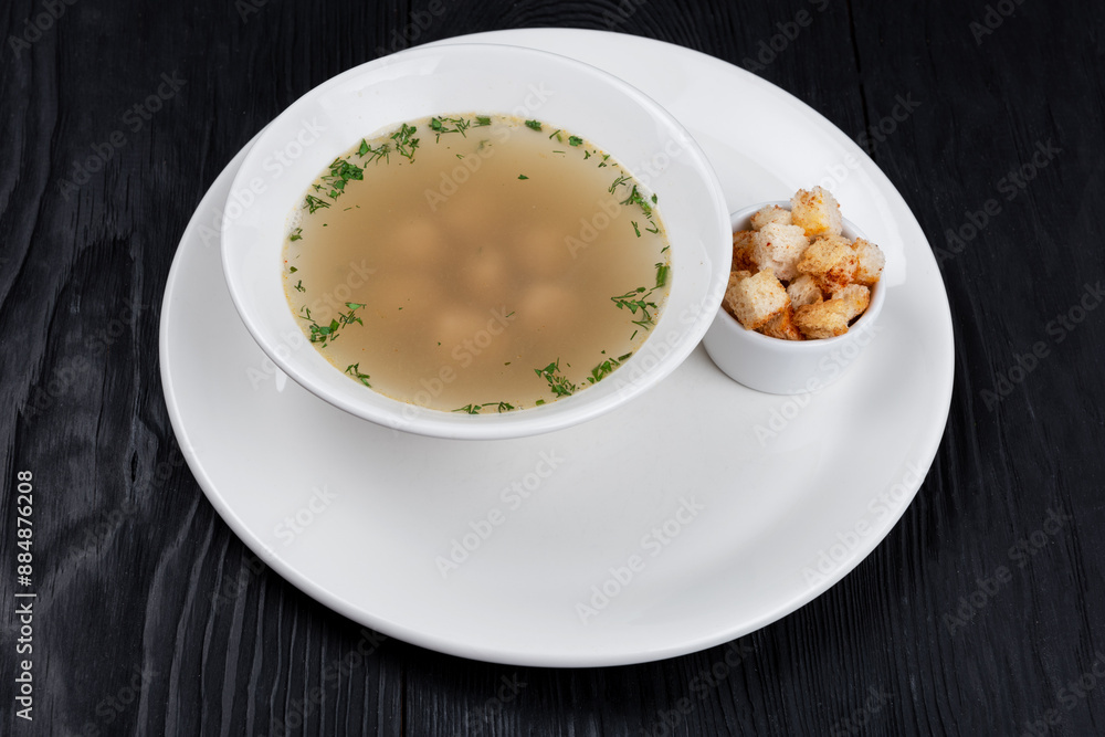 Chicken soup bouillon in a plate with chicken meatballs and croutons Chicken soup bouillon in a plate with chicken meatballs and croutons