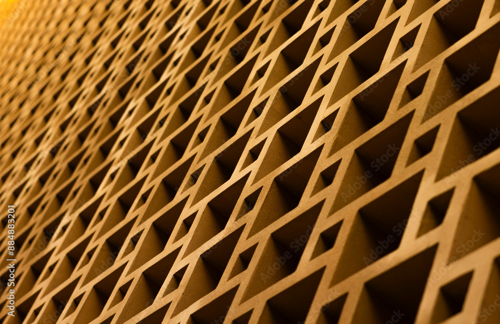 A close-up view of a repeating geometric pattern on a wall. The squares are made of a brown material and create a sense of depth and texture. A close-up view of a repeating geometric pattern on a wall. The squares are made of a brown material and create a sense of depth and texture.