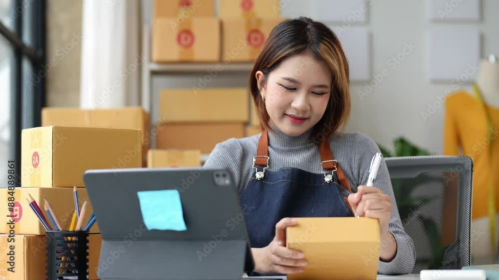 SME entrepreneur Small business entrepreneurs Online selling ideas,Happy Young Asian business owner work on computer and a boxs at home,delivery SME procurement package box deliver to customers. SME entrepreneur Small business entrepreneurs Online selling ideas,Happy Young Asian business owner work on computer and a boxs at home,delivery SME procurement package box deliver to customers.