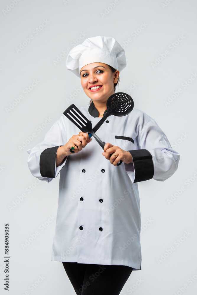 Young Indian asian female chef smiling with spatula - professional culinary expert Young Indian asian female chef smiling with spatula - professional culinary expert