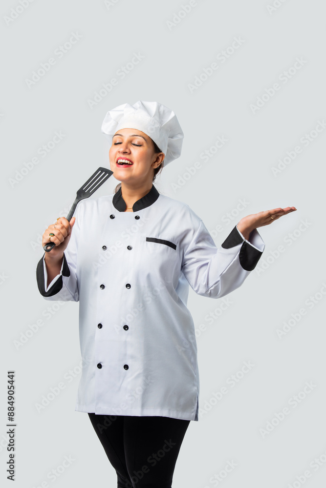 Young Indian asian female chef smiling with spatula - professional culinary expert Young Indian asian female chef smiling with spatula - professional culinary expert