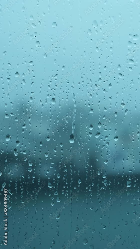 Close-up of rain droplets falling on window. Rainy day.
Close-up of rain droplets falling on window. Rainy day.