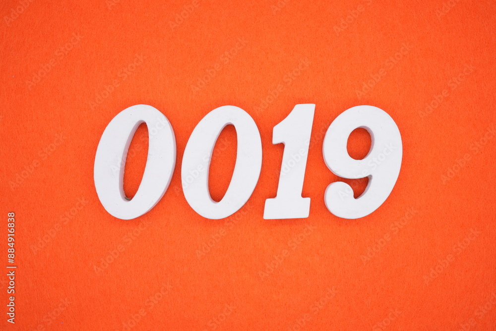 The numbers are made of white painted wood. Placed on the floor was orange paper. The numbers are made of white painted wood. Placed on the floor was orange paper.
