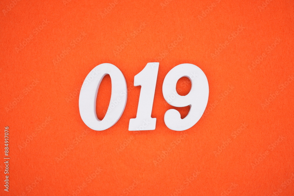 The numbers are made of white painted wood. Placed on the floor was orange paper. The numbers are made of white painted wood. Placed on the floor was orange paper.