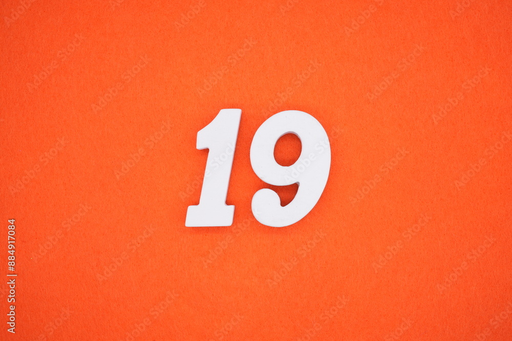 The numbers are made of white painted wood. Placed on the floor was orange paper. The numbers are made of white painted wood. Placed on the floor was orange paper.