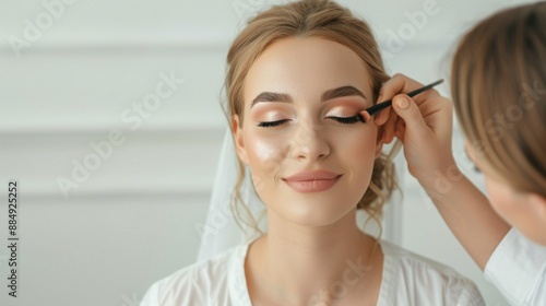 Professional bridal makeup artist working on bride with soft lighting, deep depth of field, ideal for text placement.