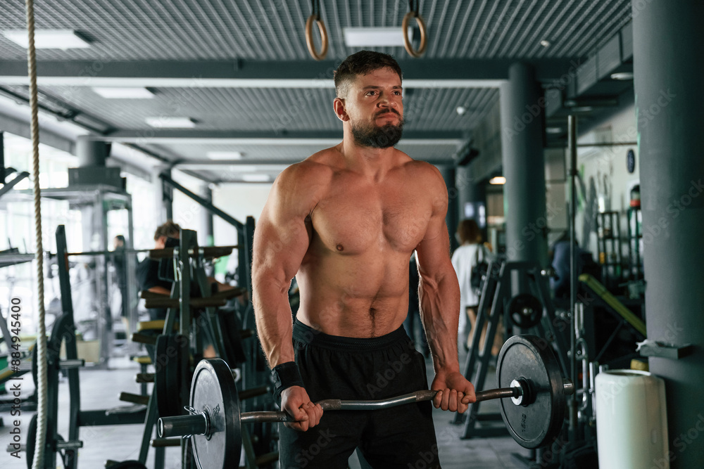 Muscular strong man is working out in the gym Muscular strong man is working out in the gym