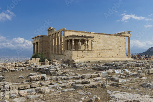 Acropolis, Athens, Greece - August 14, 2023: Summer view of stone ruins and a building with pillars and wall at Erechtheion Temple
