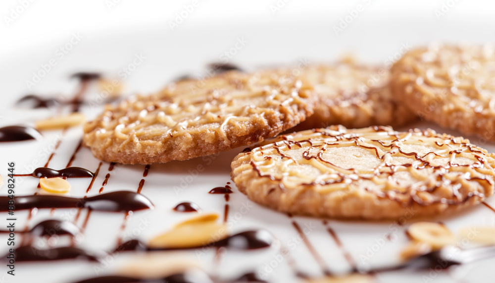 delicate Florentine cookies, featuring lace-like, caramelized almond and honey discs with a dark chocolate drizzle, set against a clean white background delicate Florentine cookies, featuring lace-like, caramelized almond and honey discs with a dark chocolate drizzle, set against a clean white background