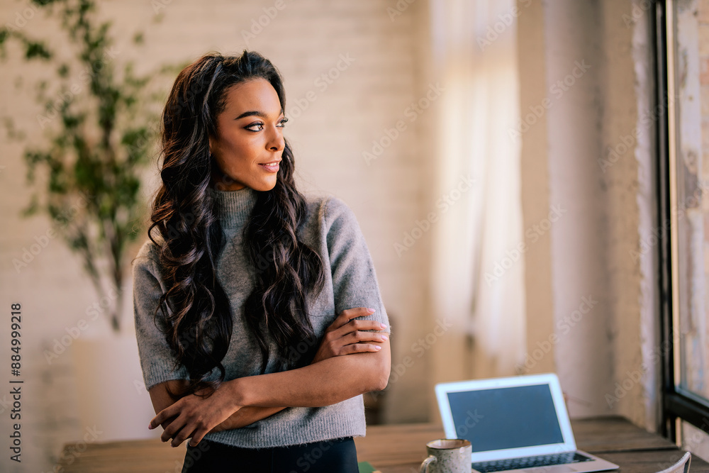 An African American woman standing at a table and looking at camera An African American woman standing at a table and looking at camera