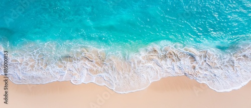 Aerial view of sea crashing on a sandy beach.