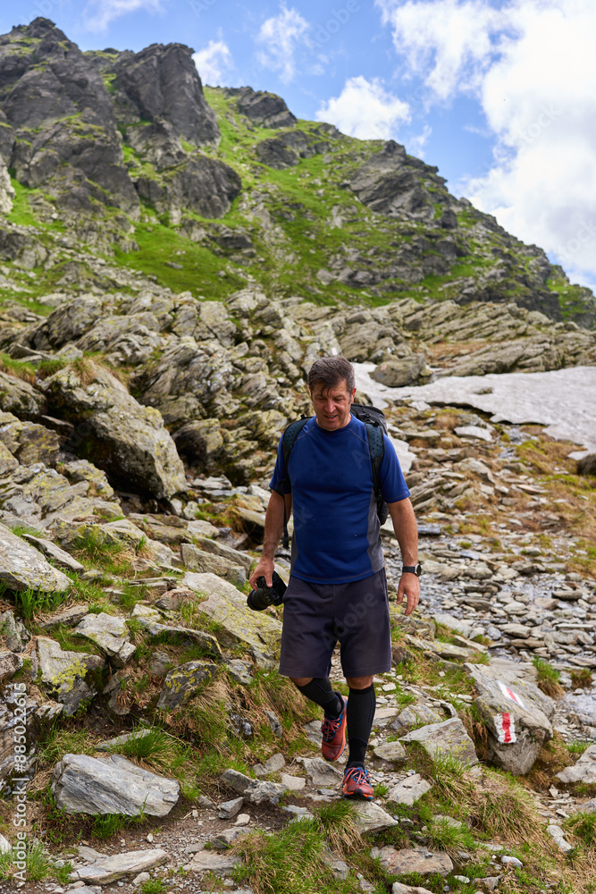 Exhausted hiker with backpack on a trail in the mountains Exhausted hiker with backpack on a trail in the mountains