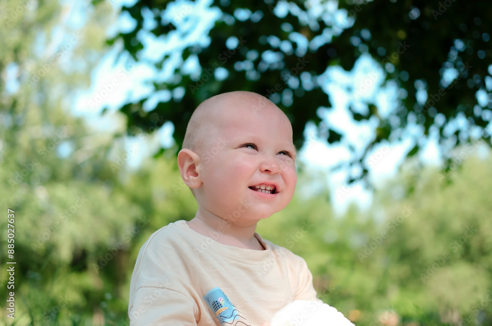 Charming, joyful child in sunny park, laughing, enjoying nature. Portrait of human emotions. Advertising of children's products. Charming, joyful child in sunny park, laughing, enjoying nature. Portrait of human emotions. Advertising of children's products.