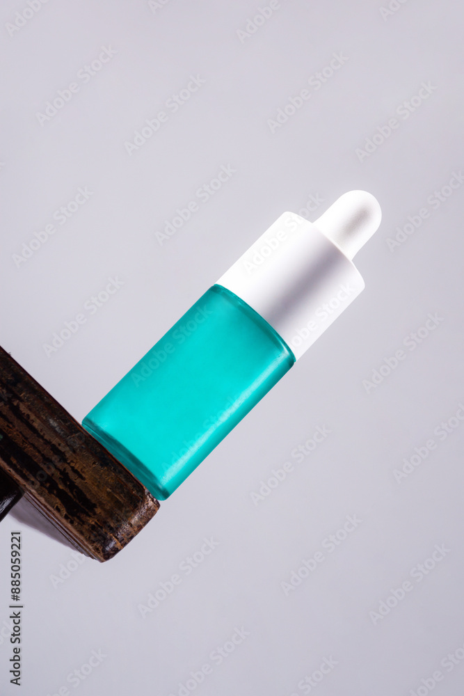 Blue glass cosmetic bottle, Skin care or sunscreen cosmetic with stylish props on grey background. Blue glass cosmetic bottle, Skin care or sunscreen cosmetic with stylish props on grey background.