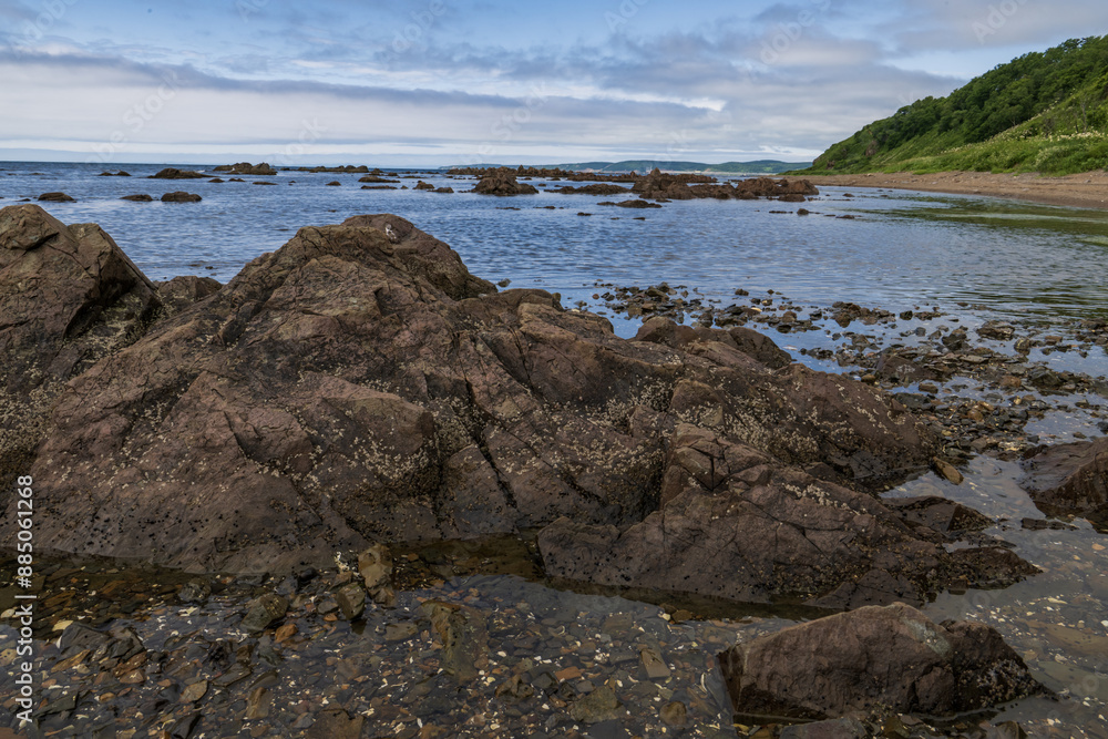 Rocks in the sea with a blue sky and clouds in the background Rocks in the sea with a blue sky and clouds in the background