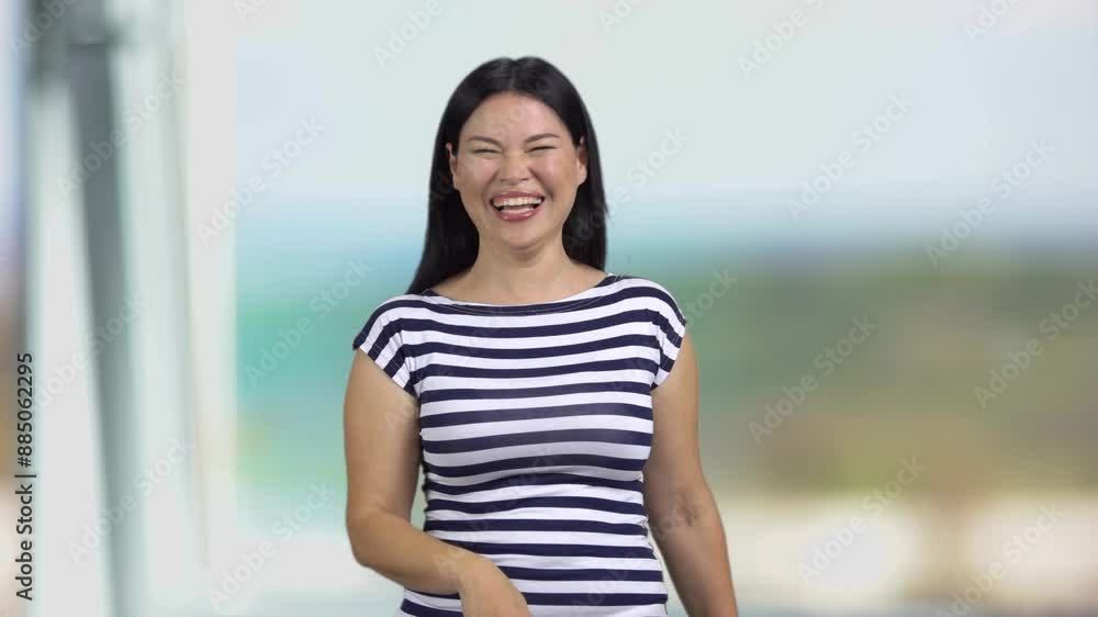 Portrait of happy brunette asian woman laughing hard. Abstract window in the background. Portrait of happy brunette asian woman laughing hard. Abstract window in the background.