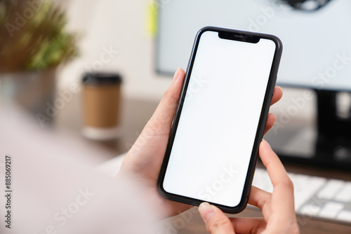 Hand holding smartphone mockup of blank screen for graphic display montage.