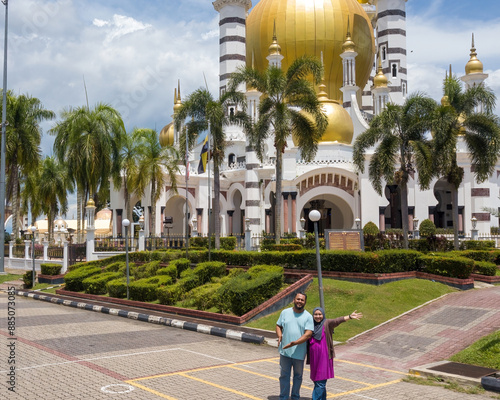 Perak, Malaysia, October 18, 2022: Muslim couple with Ubudiah mosque in Kuala Kangsar. photo