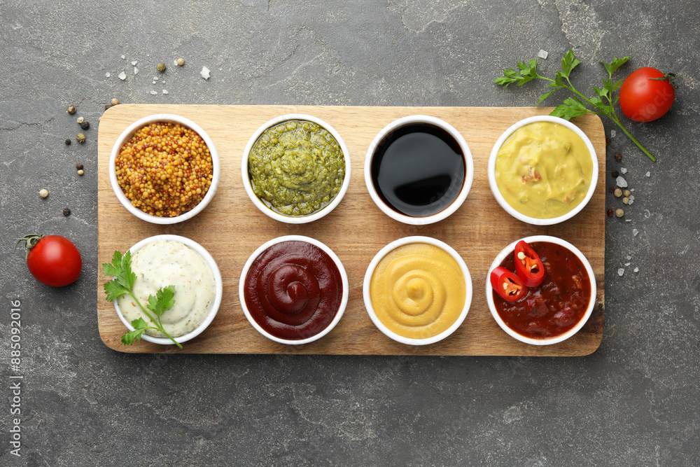 Many different sauces and spices on grey table, flat lay Many different sauces and spices on grey table, flat lay