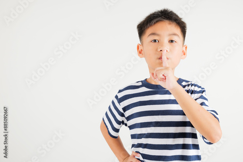 фотографія Young kid boy making finger on lips mouth silent quiet gesture, Happy Asian prim