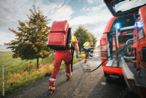 Paramedic and doctor of emergency medical medical service in blurred motion. Team of rescuers running to traffic accident. Themes rescue, urgency and health care..